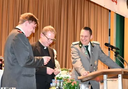 Stadtjungschützenkönig Felix Funke, Pfarrer Klaus Engel und der Bigger Major Dominik Flügge bei der Auslosung der Schießreihenfolge.